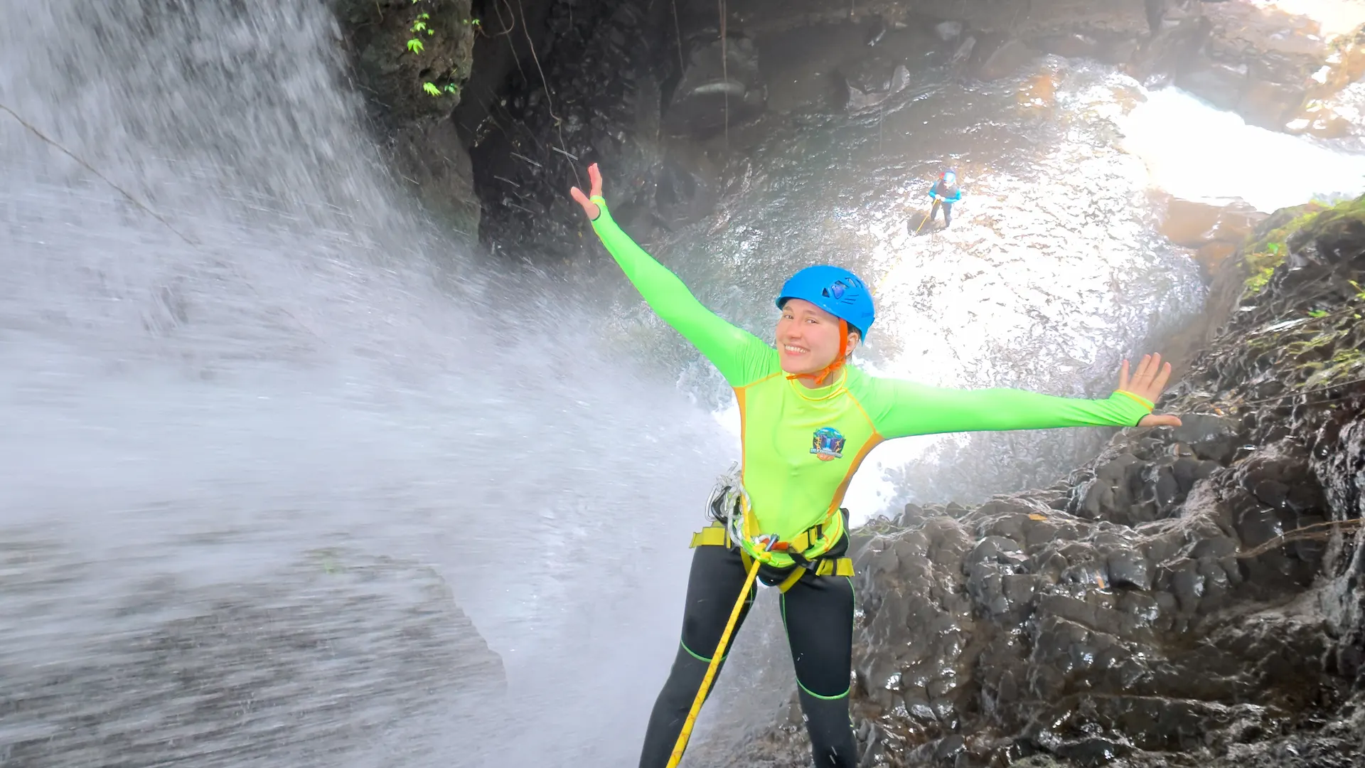 A guest rappelling a jungle waterfall on the Brave Trail canyoning trip in North Bali