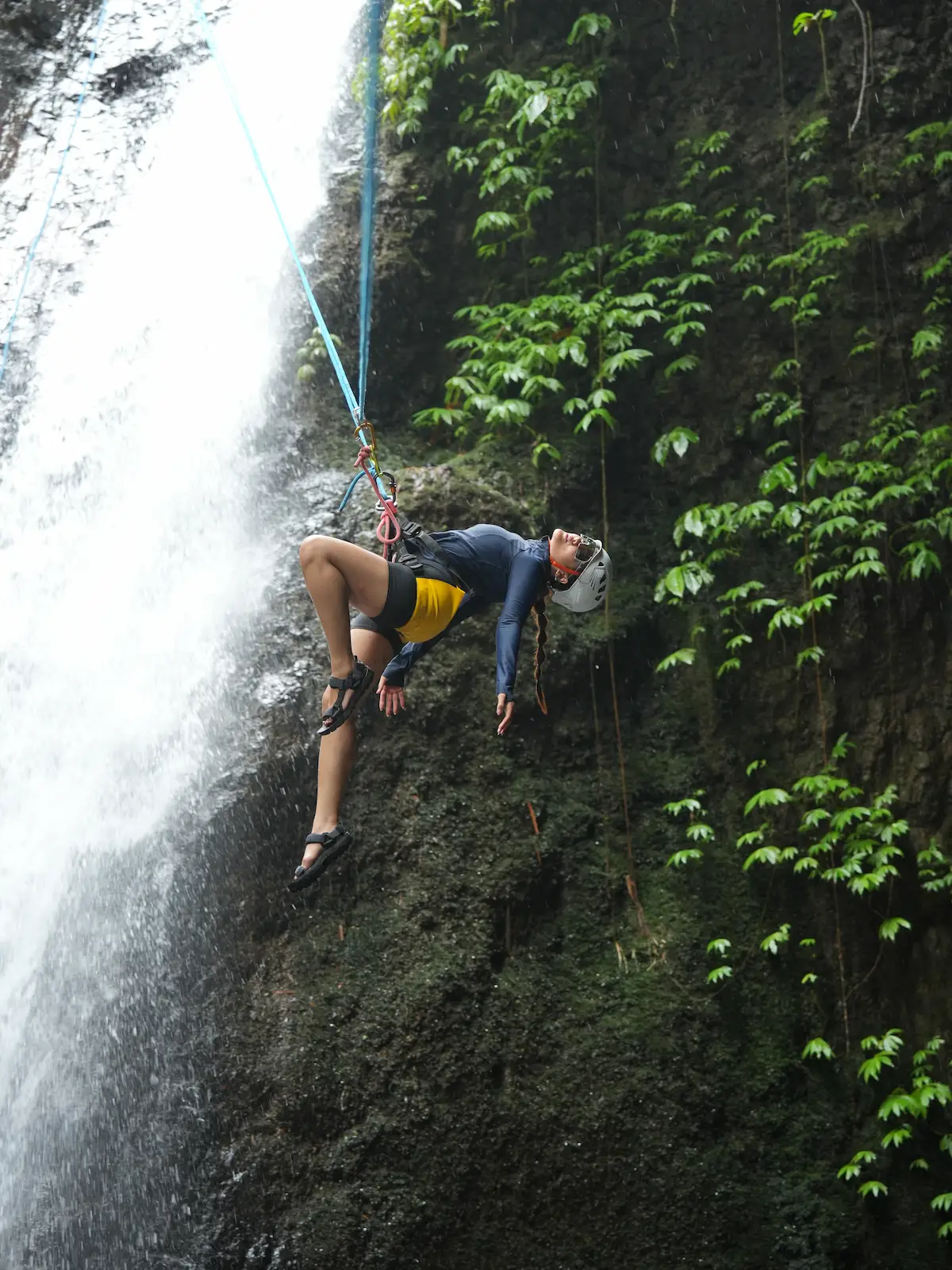 Gaya bebas bergelantungan di tali di air terjun Gitgit